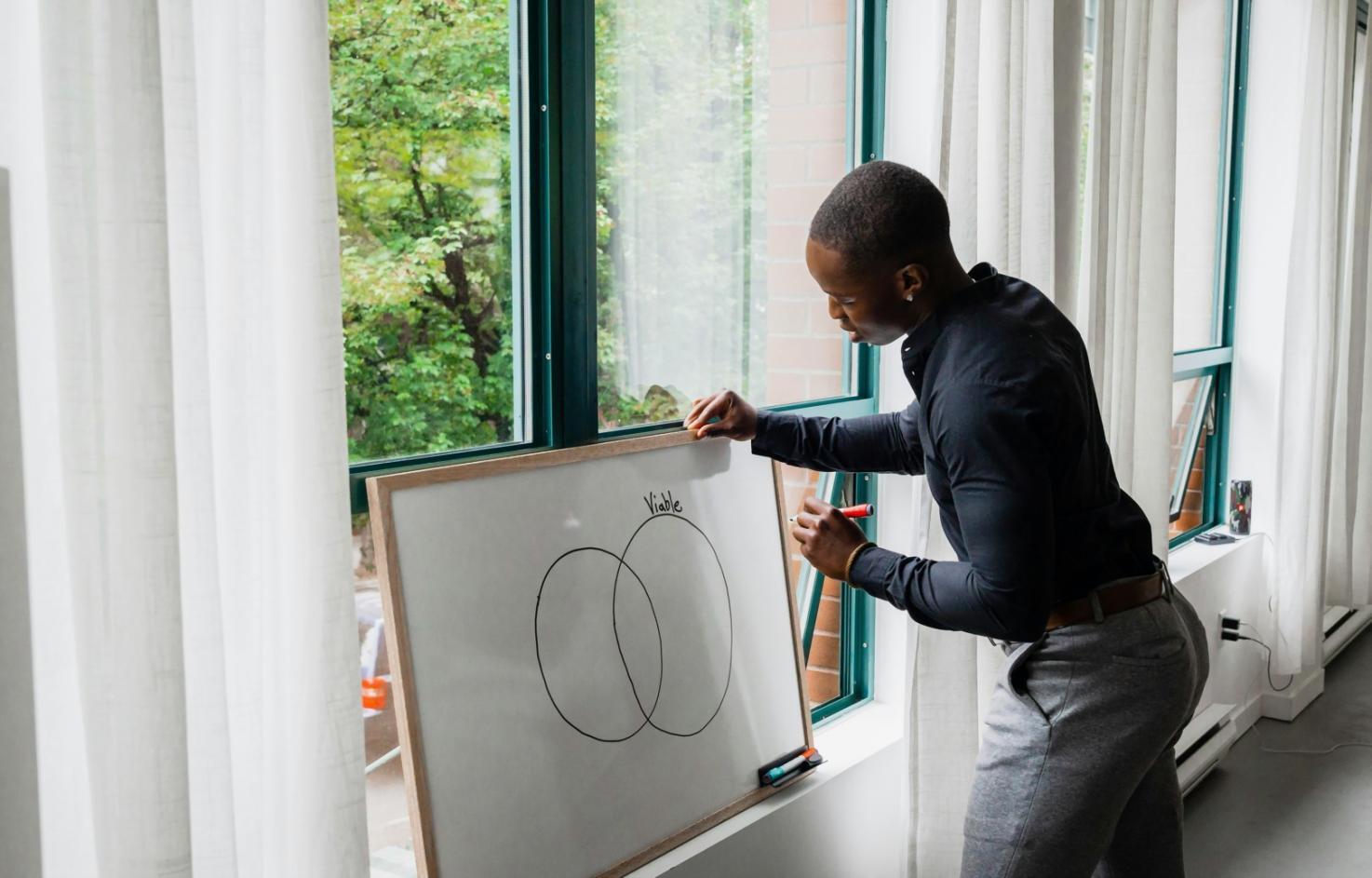 Studierende bei konzentrierter Arbeit an Illustrationsprojekten in hellem Atelierraum